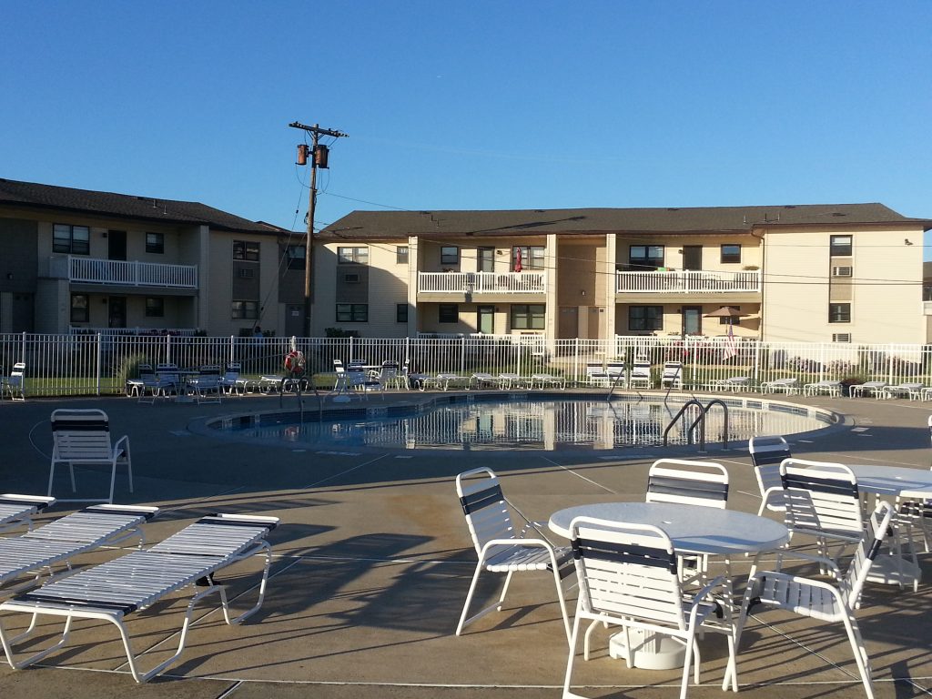 The Wharfside Manor community pool overlooks the river with a barbecue area next to it.