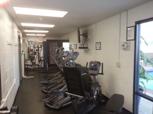 On the ground level next to the indoor pool is a clean, well lit fitness room.