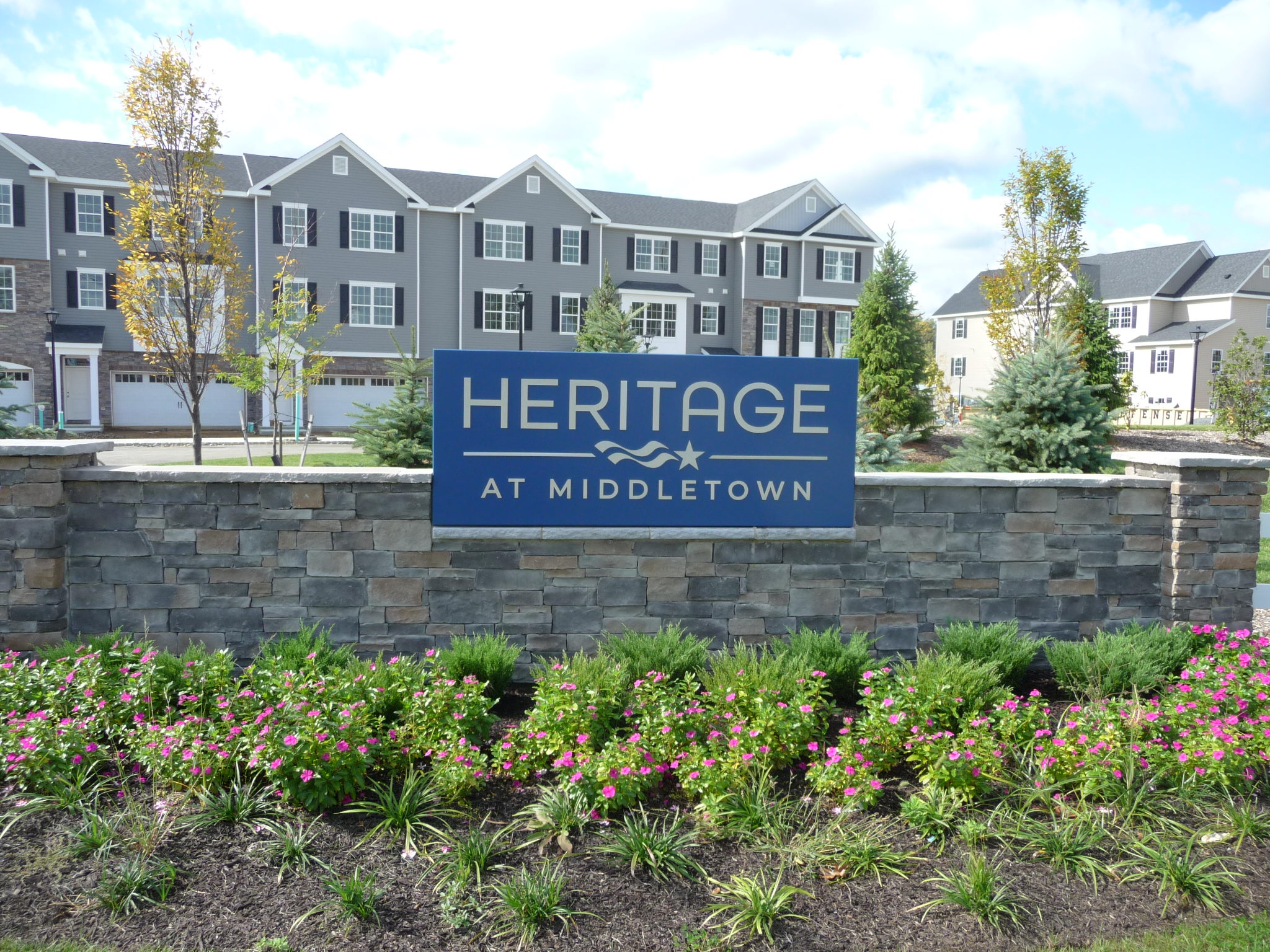 Picture of the entry sign with residences in the background.